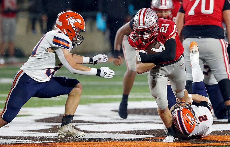 Shelby High School's Travis Slone (21) is tackled by Galion High School's Samuel Evans (2) and Kale Early (30) during OHSAA Division IV regional finals high school football action Friday, Nov. 21, 2025 at Arlin Field. TOM E. PUSKAR/MANSFIELD NEWS JOURNAL