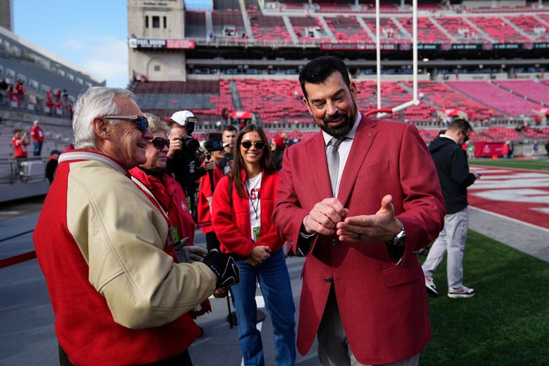 Ohio State coach Ryan Day talks to former Buckeyes coach and current Ohio lieutenant governor Jim Tressel prior to OSU's Nov. 22 game against Rutgers.