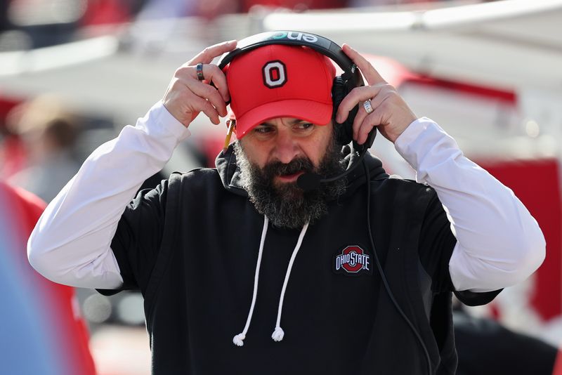 Nov 22, 2025; Columbus, Ohio, USA; Ohio State Buckeyes defensive coordinator Matt Patricia puts on his headset before the game against the Rutgers Scarlet Knights at Ohio Stadium. Mandatory Credit: Joseph Maiorana-Imagn Images
