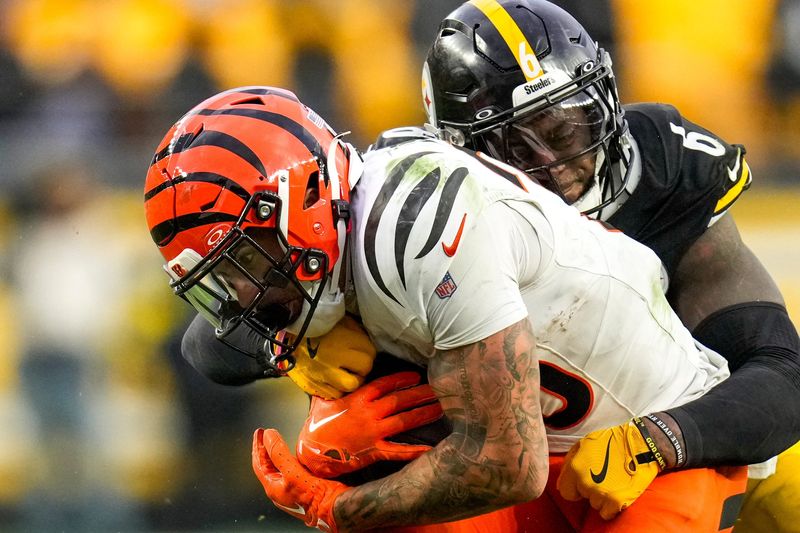 Cincinnati Bengals running back Chase Brown (30) fights a tackle from Pittsburgh Steelers linebacker Patrick Queen (6) in the fourth quarter of the NFL Week 11 game between the Pittsburgh Steelers and the Cincinnati Bengals at Acrisure Stadium in Pittsburgh on Sunday, Nov. 16, 2025. The Bengals lost 34-12.