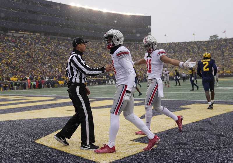 Ohio State Buckeyes wide receiver Garrett Wilson (5) celebrates a touchdown with wide receiver Jaxon Smith-Njigba (11) during the second quarter of the NCAA football game at Michigan Stadium in Ann Arbor on Sunday, Nov. 28, 2021.