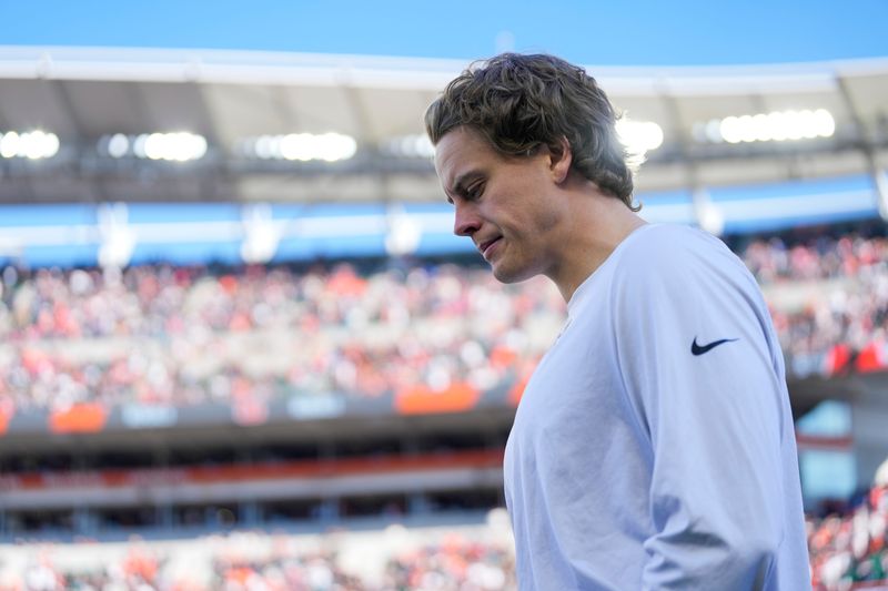 Nov 23, 2025; Cincinnati, Ohio, USA; Injured Cincinnati Bengals quarterback Joe Burrow (9) walks onto the field before the first quarter against the New England Patriots at Paycor Stadium. Mandatory Credit: Sam Greene-USA TODAY Network via Imagn Images