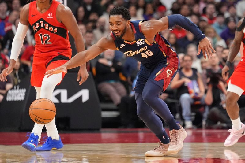 Nov 24, 2025; Toronto, Ontario, CAN; Cleveland Cavaliers guard Donovan Mitchell (45) tries to get control of the ball against the Toronto Raptors during the first half at Scotiabank Arena. Mandatory Credit: John E. Sokolowski-Imagn Images