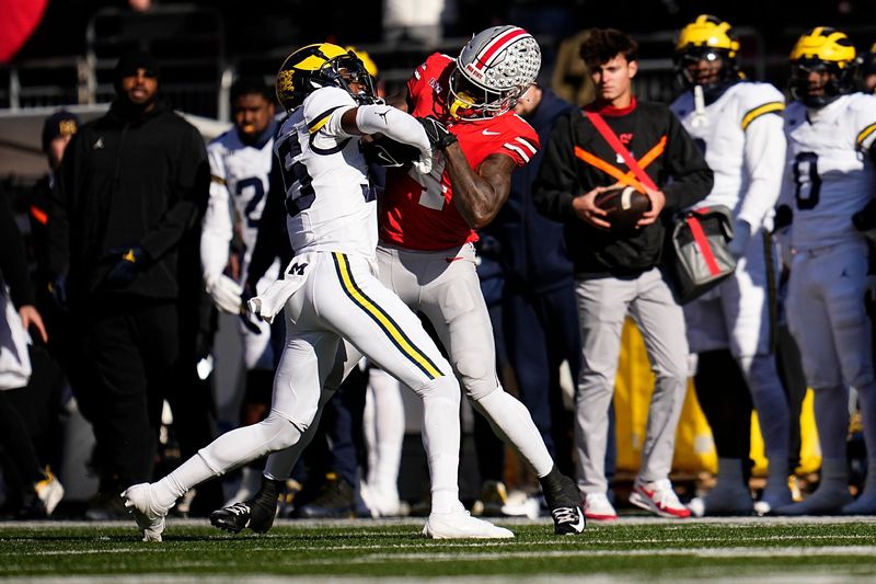 Michigan Wolverines defensive back Jyaire Hill (35) tackles Ohio State Buckeyes wide receiver Jeremiah Smith (4) during the first half of the NCAA football game at Ohio Stadium in Columbus on Saturday, Nov. 30, 2024.