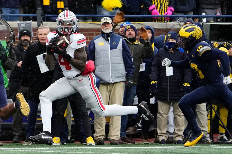 Ohio State Buckeyes wide receiver Jeremiah Smith (4) catches a touchdown pass in front of Michigan Wolverines defensive back Zeke Berry (10) during the NCAA football game at Michigan Stadium in Ann Arbor, Mich. on Nov. 29, 2025.