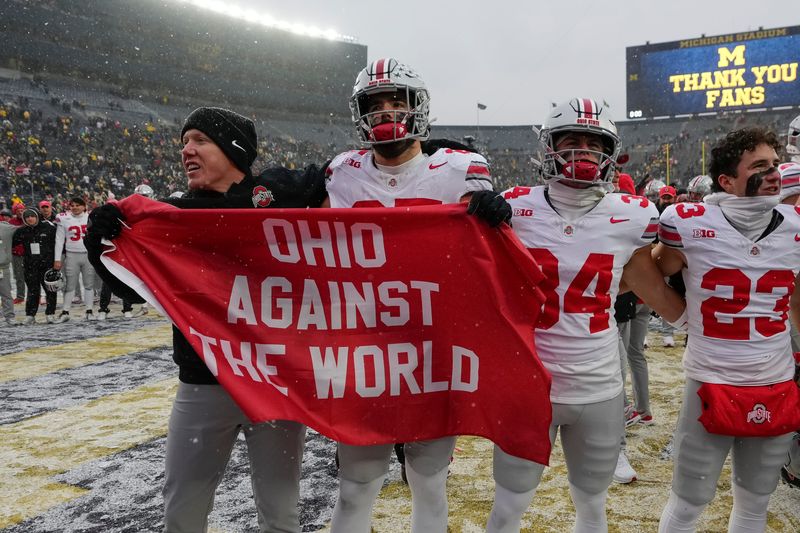 Ohio State tight ends coach Keenan Bailey celebrates with tight end Bennett Christian (85), receiver Brennen Schramm (34) and receiver Nolan Baudo (23) following a win at Michigan on Nov. 29.