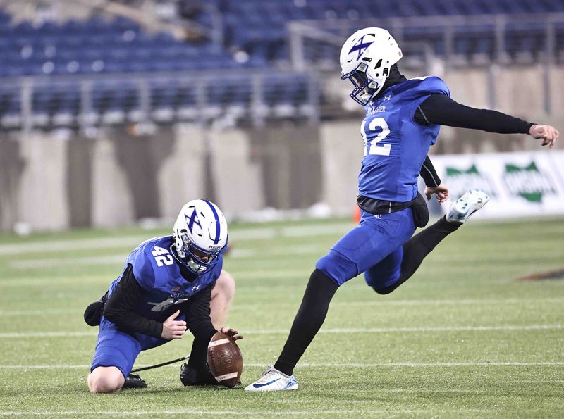 St. Xavier kicker Owen Davidson (12) and holder William Schwartz (42) warm up before the OHSAA Division I state championship football game between St. Xavier and Olentangy Orange, Friday, Dec. 5, 2025, in Canton.