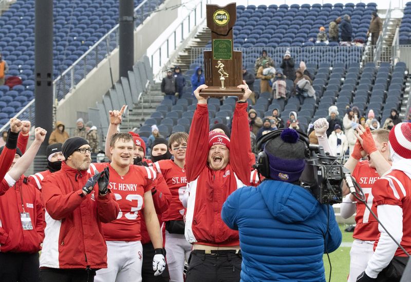 St. Henry head coach Josh Werling raises the Division VII state championship trophy after defeating Hillsdale 37-3, Dec. 6, 2025, in Canton.