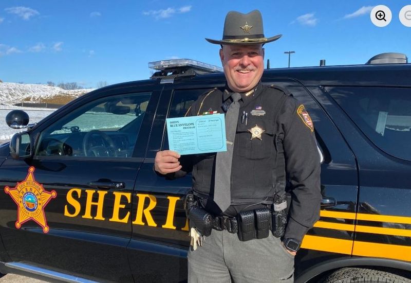 Deputy Chad Carruthers of the Stark County Sheriff's Office holds a blue envelope that is part of a statewide program to help individuals with disabilities during interactions with law enforcement officers.