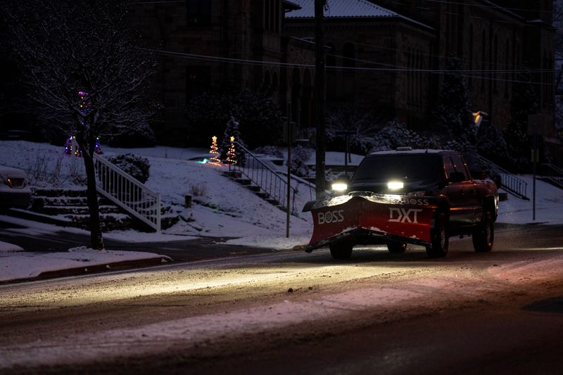 A truck with an attached snow plow drives down 8th Street in West Price Hill on Dec. 12, 2025.