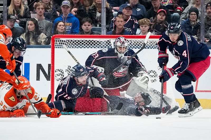 Blue Jackets center Cole Sillinger (4) carries the puck away as center Charlie Coyle (3) slides to stop a shot in front of goaltender Jet Greaves (73) and defenseman Dante Fabbro (15). Columbus won this game against the Ducks on Dec. 16, 2025, 4-3 in overtime.