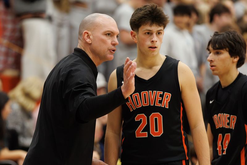 Hoover coach Mike Bluey talks with Brady McCann during the second half at Green, Tuesday, Dec. 16, 2025.