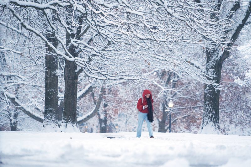 People walk through the winter wonderland of Ohio State University’s Mirror Lake and the Oval after several inches of snow fell early in the morning Tuesday, Dec. 2, 2025.