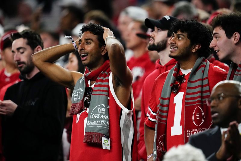 Ohio State Buckeyes fans react to a pick-six interception thrown by Julian Sayin during the Cotton Bowl at AT&T Stadium in Arlington, Texas for the College Football Playoff quarterfinal game against the Miami Hurricanes on Dec. 31, 2025.
