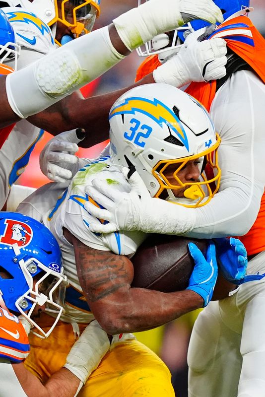 Week 18: Los Angeles Chargers running back Jaret Patterson (32) is tackled by the Denver Broncos during the third quarter at Empower Field at Mile High. The Broncos won the game, 19-3, to clinch home-field advantage throughout the AFC playoffs.