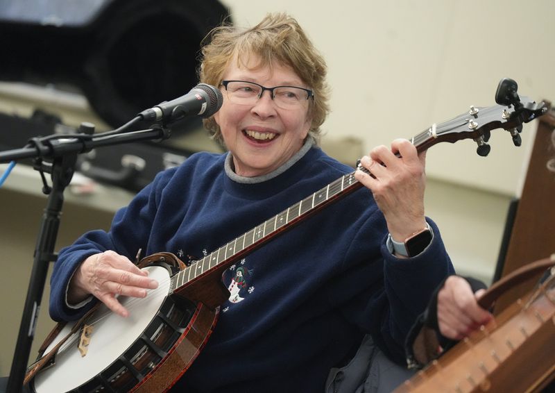 Linda Zahirsky smiles as she plays the banjo during a recent music jam session at the Canal Fulton Public Library.