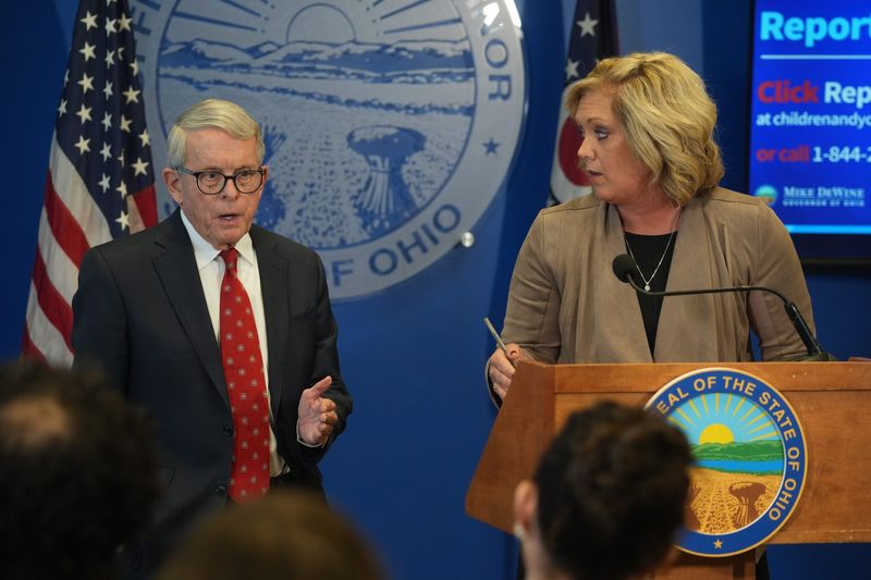 Kara Wente, Director, Ohio Department of Children and Youth (right), listens to Ohio Gov. Mike DeWine as they respond to online allegations that a Somali immigrant-run nonprofit registered 40 day care providers on the same day. They held a news conference Jan. 5, 2026.