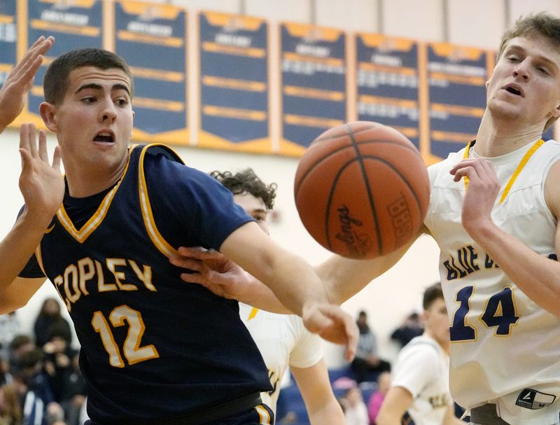 Copley’s Colton Adair (12) and Tallmadge’s Kaden Heller (14) go after the ball during their game at Tallmadge High School on Jan. 9, 2026.