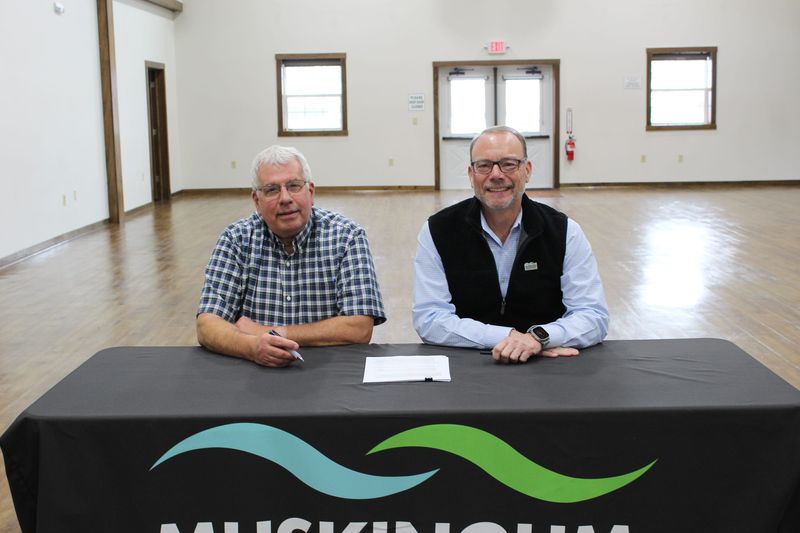 George Broughton, left, and Craig Butler, MWCD executive director, sign a document to complete the purchase of the 700-acres Broughton Nature and Wildlife Area.