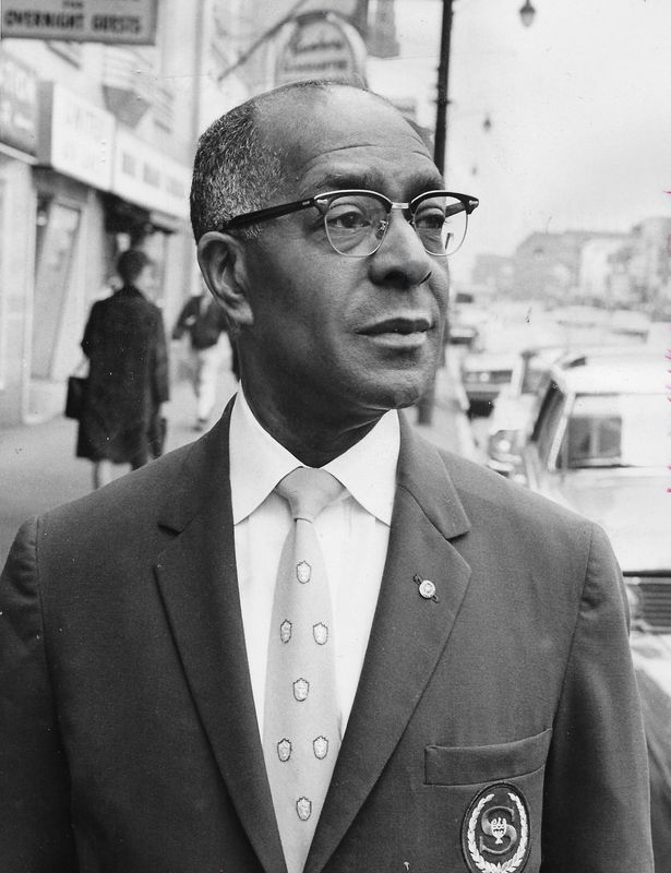 Former bell captain R.C. Glenn, 62, superintendent of service at the Mayflower Hotel in Akron, stands on South Main Street in 1964. He had worked at the downtown hotel since the week before it opened in 1931.