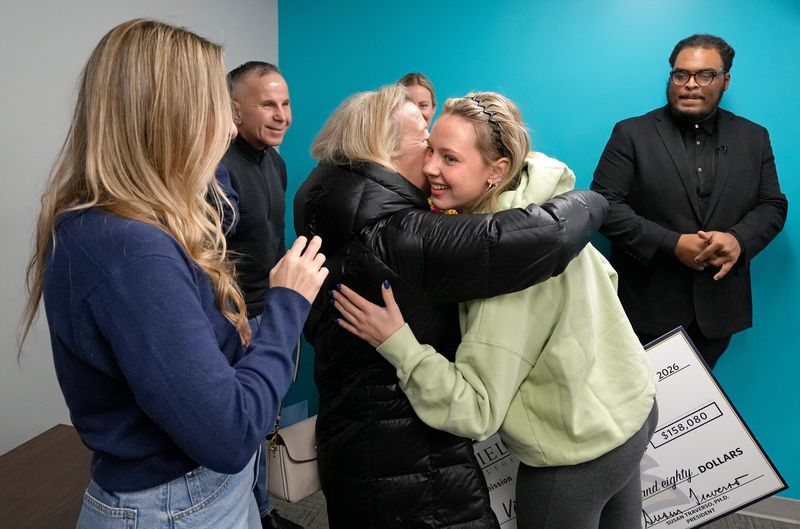 Lake High School senior Violet Seaman, facing, hugs her grandmother Julie Soduk after being surprised with a full tuition scholarship to Thiel College from admissions counselor Mez Tobias.