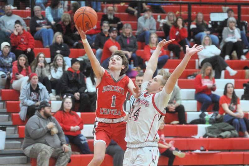 Buckeye Central's Hunter Caudill slips past Bucyrus' Kayden Baxter for a layup.