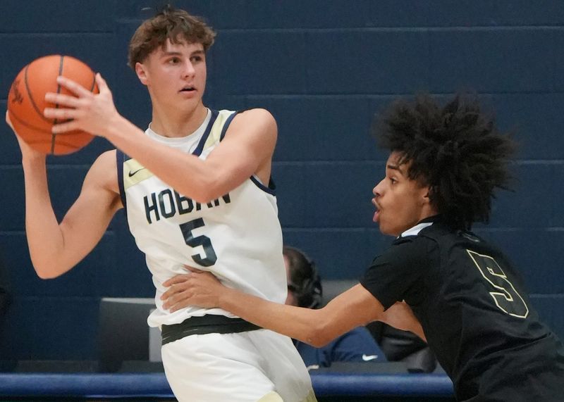 Archbishop Hoban’s Arri Caporaletti (5) looks to pass as St. Vincent–St. Mary’s Terek Harris (5) defends during the game at University of Akron’s James A. Rhodes Arena in Akron on Jan. 23, 2026.