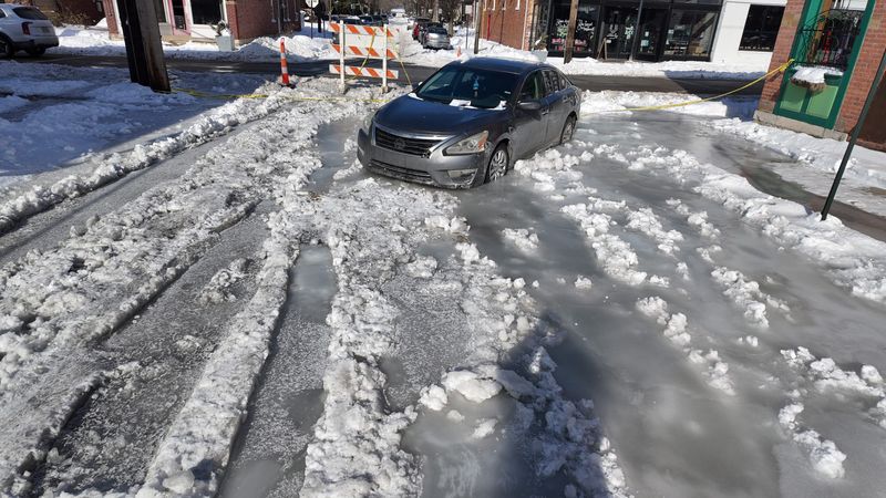 A car is frozen in ice after a water line break flooded S. Bruck St. at Whittier Wednesday, Jan. 28, 2025. Three vehicles were affected by the ice. The ice was beside the Hey Hey Bar & Grill, 361 E. Whittier St.