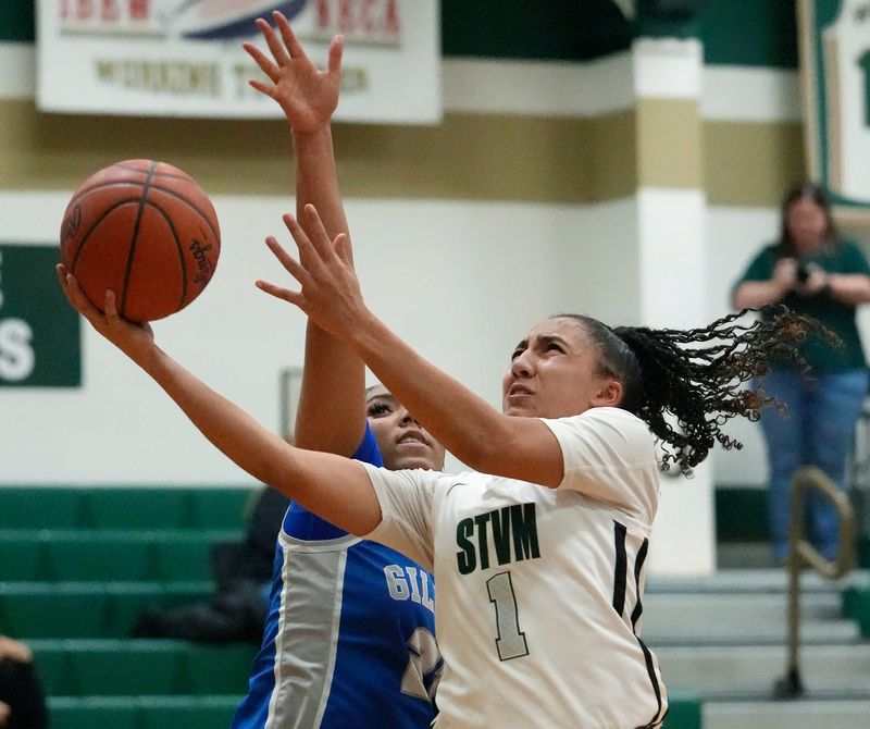 St. Vincent-St. Mary's Melania Cornute goes to the basket as Gilmour Academy's Anaya Domanski (21) defends, Jan. 28, 2026.