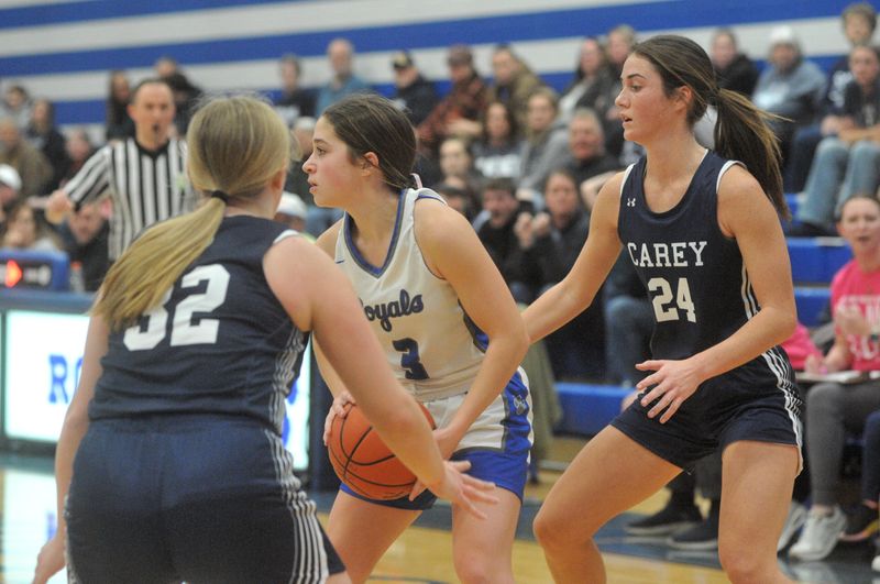 Wynford's Megan Young looks to get rid of the ball with Carey's Emily Brodman (24) and Bayah Harsanje (32) closing in.