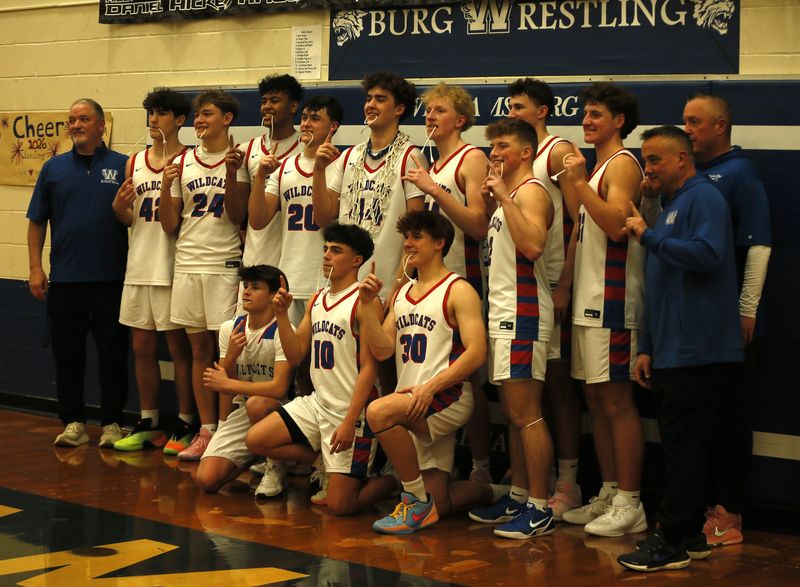Williamsburg players and coaches pose with the net after they won the SBAAC-National as Williamsburg defeated Bethel-Tate 72-40 in boys basketball Jan. 30, 2026, at Williamsburg.