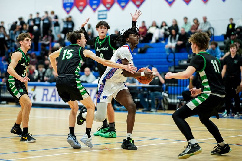 Ravenna’s Curtis Ross (2) drives to the basket under pressure from Mogadore, Feb. 3, 2026, at Ravenna High School in Ravenna, Ohio.