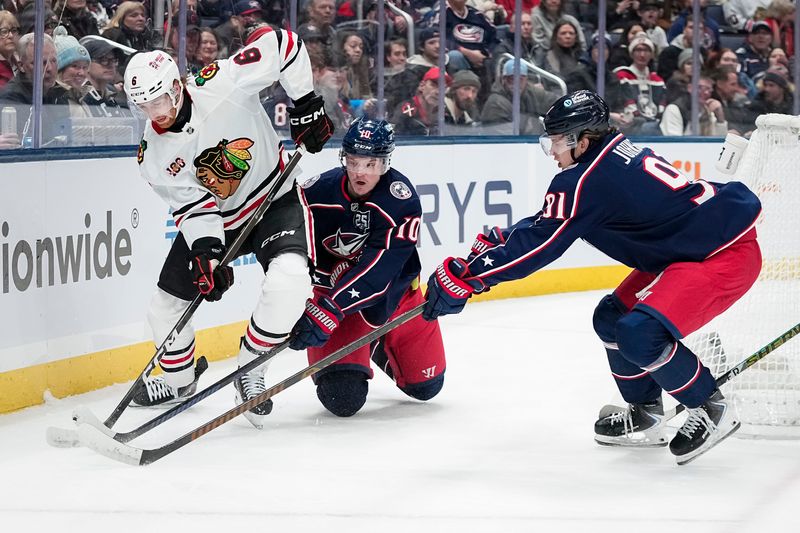 Blue Jackets forwards Dmitri Voronkov (10) and Kent Johnson (91) defend against the Blackhawks on Feb. 4.