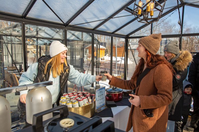 Alayna Mahler, with Gideon Owen Wine Co., serves up some hot chocolate at the Catawba Island Ice Shove event on Feb. 7.