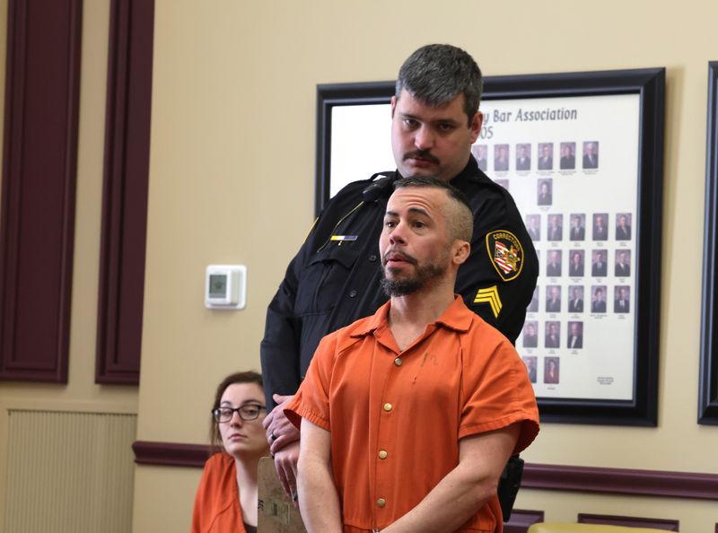 Sgt. Ron Welch III stands behind Rylan Burrie in Court of Common Pleas on Feb. 9, prior to Burrie's sentencing. He was found guilty of eight charges in a December trial and received the maximum term of 29 years in prison.