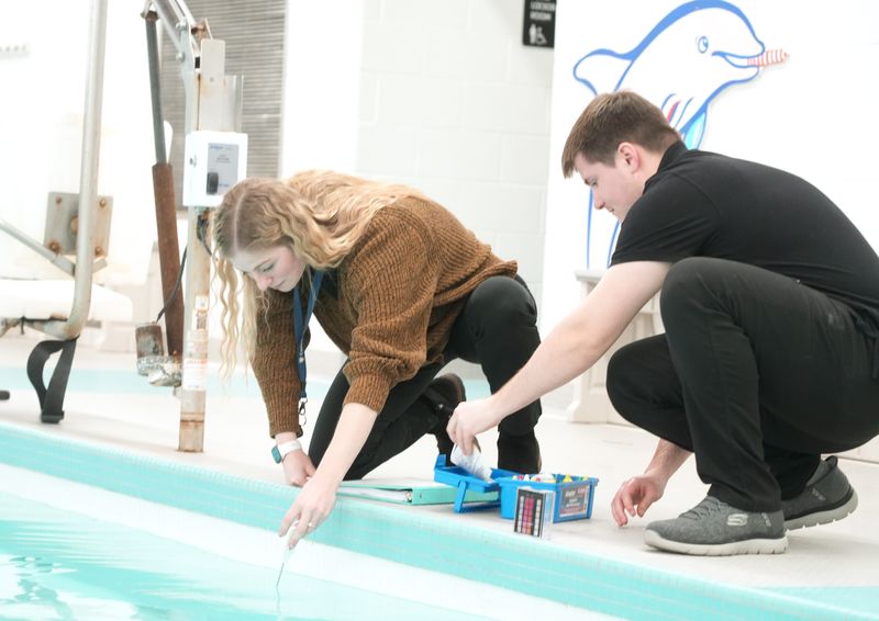 Valerie Fletcher, left, an environmental health specialist, and Evan Kelsey, a lab technician with Canton's Environmental Health Division, test pool water at the Eric Snow YMCA.