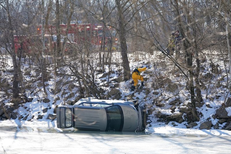 A Columbus Division of Fire heavy rescue crew works to pull a Kia Soul off of the frozen Olentangy River that crashed Feb. 13 while traveling on north State Route 315 just north of Bethel Road. The vehicle went down an embankment before landing on the frozen river. A water rescue responded to secure and safety evacuate the vehicle.