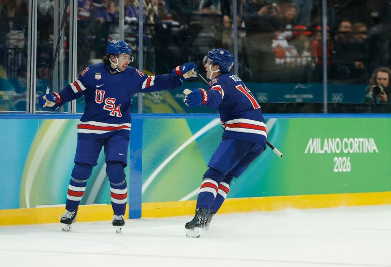 Feb 18, 2026; Milan, Italy; Quinn Hughes (43) of the United States celebrates with Matt Boldy (12) of the United States after scoring the winning goal in overtime against Sweden in a men's ice hockey quarterfinal during the Milano Cortina 2026 Olympic Winter Games at Milano Santagiulia Ice Hockey Arena. Mandatory Credit: Geoff Burke-Imagn Images