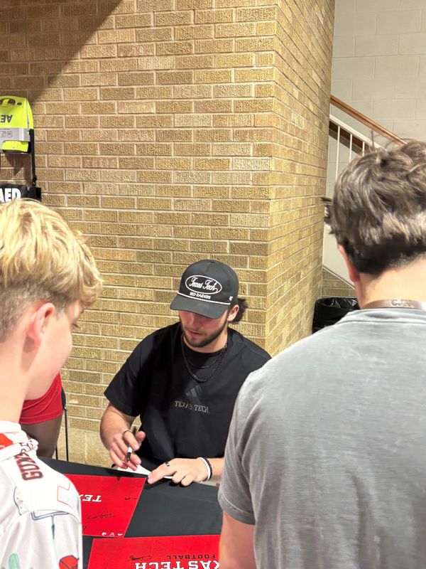 Former Cincinnati quarterback Brendan Sorsby signs autographs before the Bearcats-Texas Tech basketball game Feb. 24 at United Supermarkets Arena.