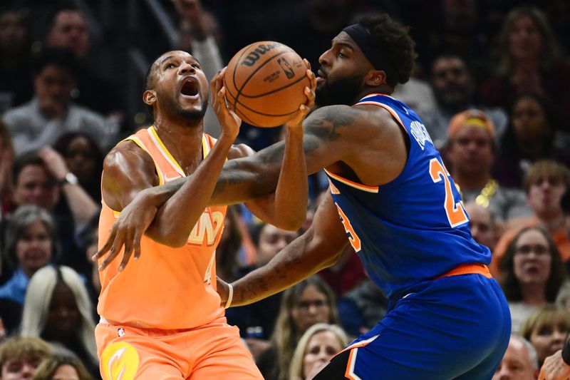 Feb 24, 2026; Cleveland, Ohio, USA; New York Knicks center Mitchell Robinson (23) fouls Cleveland Cavaliers center Evan Mobley (4) during the first half at Rocket Arena. Mandatory Credit: Ken Blaze-Imagn Images