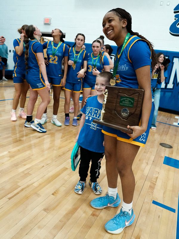 Teriauna Brandford, of West Muskingum, poses with a young fan after hitting the game-winning shot in a 30-28 win against Belmont Union Local in a Division V East Distrct final on Saturday, Feb. 28 at Cambridge's Gene Ford Gymnasium. Brandford's three with one second left was the Tornadoes' only 3-pointer of the game as they reached their second regional tournament in four years.