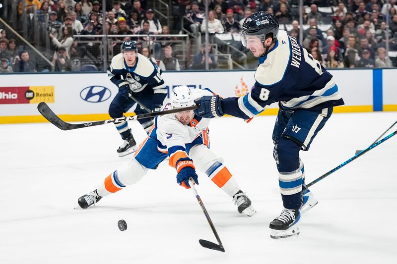New York Islanders defenseman Adam Pelech (3) deflects the shot from Columbus Blue Jackets defenseman Zach Werenski (8) during the first period of the NHL hockey game at Nationwide Arena in Columbus on Feb. 28, 2026.