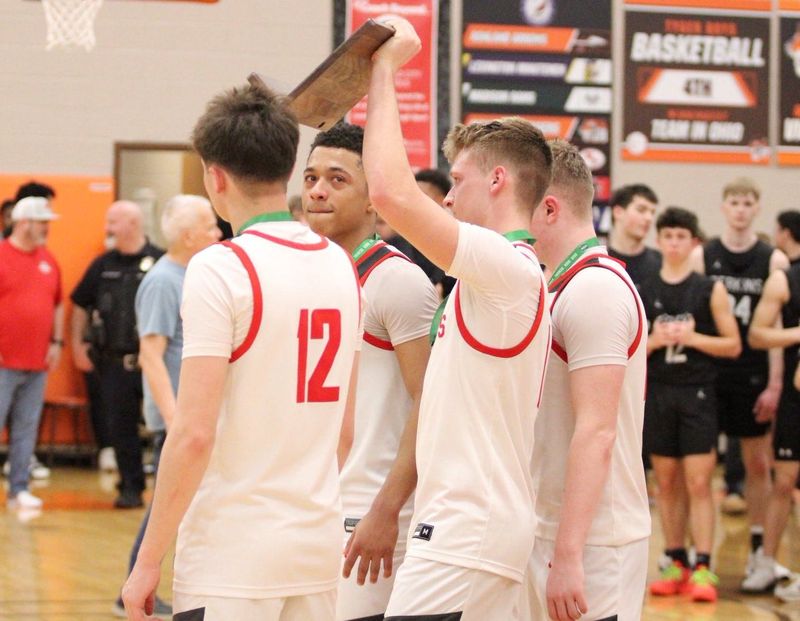 Shelby seniors Brayden DeVito, Landon Foltz, Gavin Miller and Avery Lambert hoist the Division IV district runner-up trophy after falling to Perkins 61-40 on Saturday, March 7 at Mansfield Senior High School.