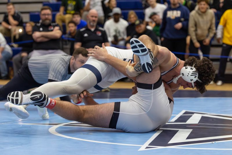 Hoban’s Brydon Feister drives down Perry’s Trent Taylor in the 285-pound championship match at the Division II Kenston district tournament March 7, 2026, in Kenston.