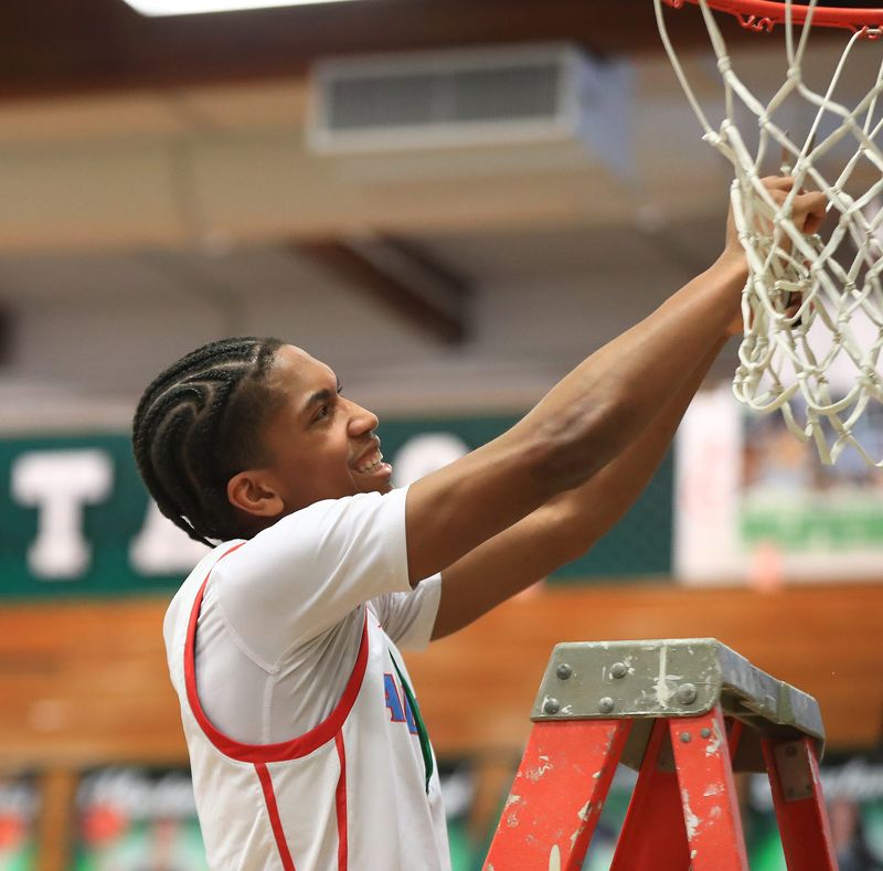 Alliance's JR Jackson cuts a strand of the net after the program won its first district title since 1983, winning a Division III district final, Saturday, March 7, 2026, at Strongsville High School.