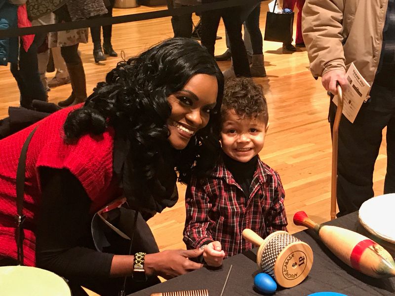 Lynette Carisa Brown and her son, Isaac Brown at a table with shaking instruments.