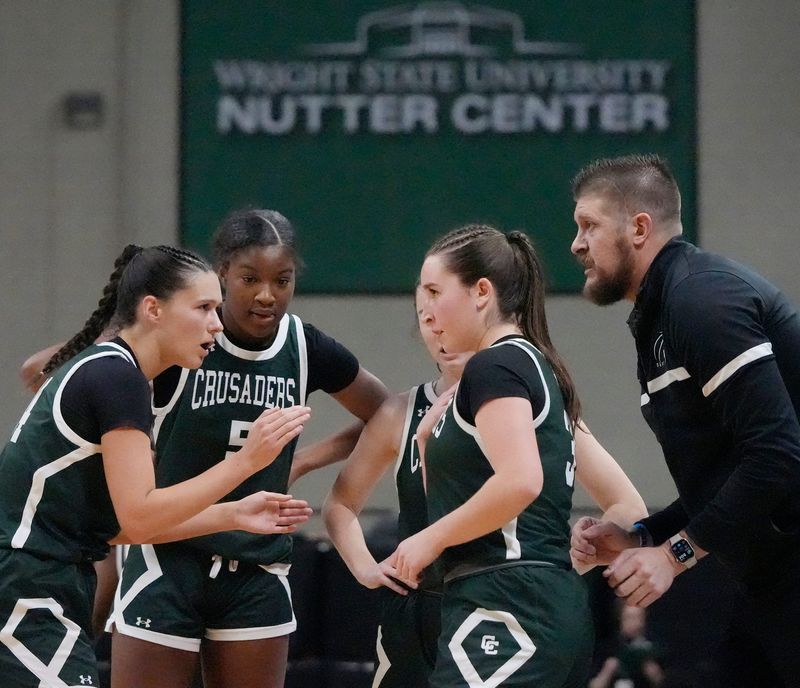 Canton Central Catholic’s Lily Belden (24), Aubrey Harris-Hall (5), Ellie Buckler (11) and Sarah Belden (3) strategize with head coach Tim Vandervaart during the girls basketball Div. VI state semifinal game against Margaretta at the Wright State University Nutter Center in Dayton on March 12, 2026.