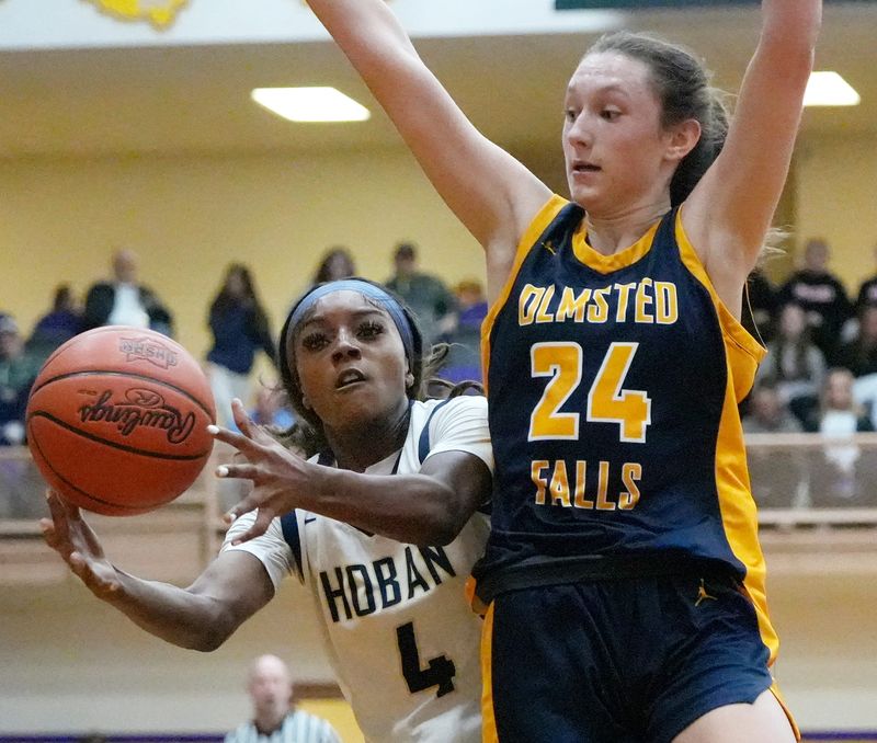 Archbishop Hoban’s Makenzie Grant (4) reaches for a rebound as Olmsted Falls' Kayleigh Schaefer (24) defends in the girls basketball Div. II state semifinal game at Butler High School in Vandalia on March 13, 2026.