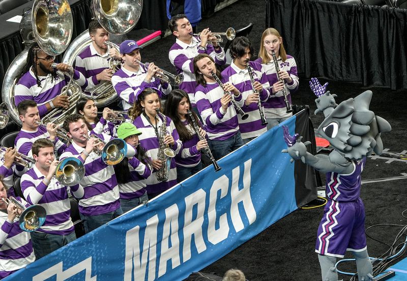 SuperFrog, the Texas Christian University (TCU) mascot, leads the Horned Frog Marching Band led by director Drew Dickey, during practice for the NCAA Men’s March Madness Tournament 2026 First and Second Rounds at Bon Secours Wellness Arena in Greenville, S.C. Wednesday, March 18, 2026.