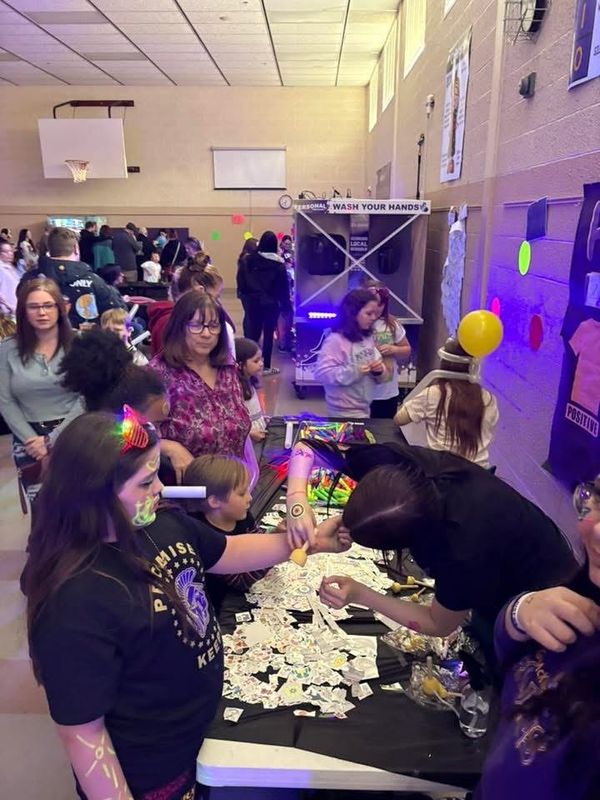 Volunteers and staff from Sebring Local Schools apply glow-in-the-dark tattoos on the arms of students at B.L. Miller Elementary School in Sebring. The activity was part of the school district's STEM/Math "Glow Night" in early March. The students enjoyed an evening of educational games and other activities that offered them the chance to use glow paint and markers.